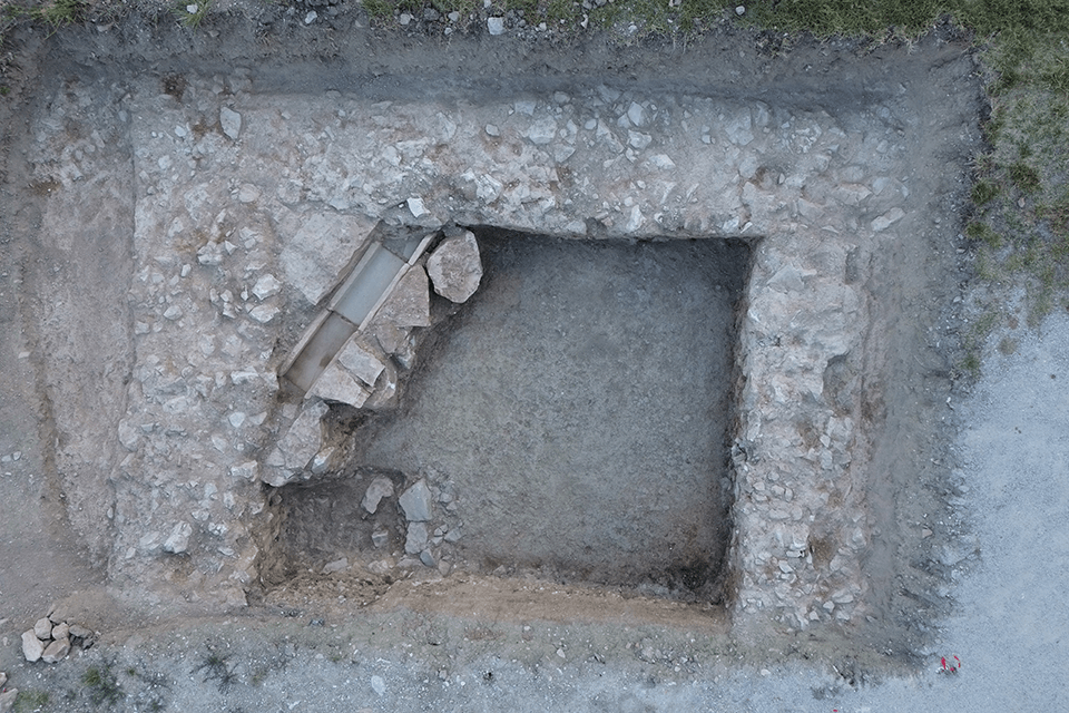 An aerial photo of the newly-discovered imperial cult ruins in Spello. Rocks form three sides of an ancient building, standing about two feet tall. 